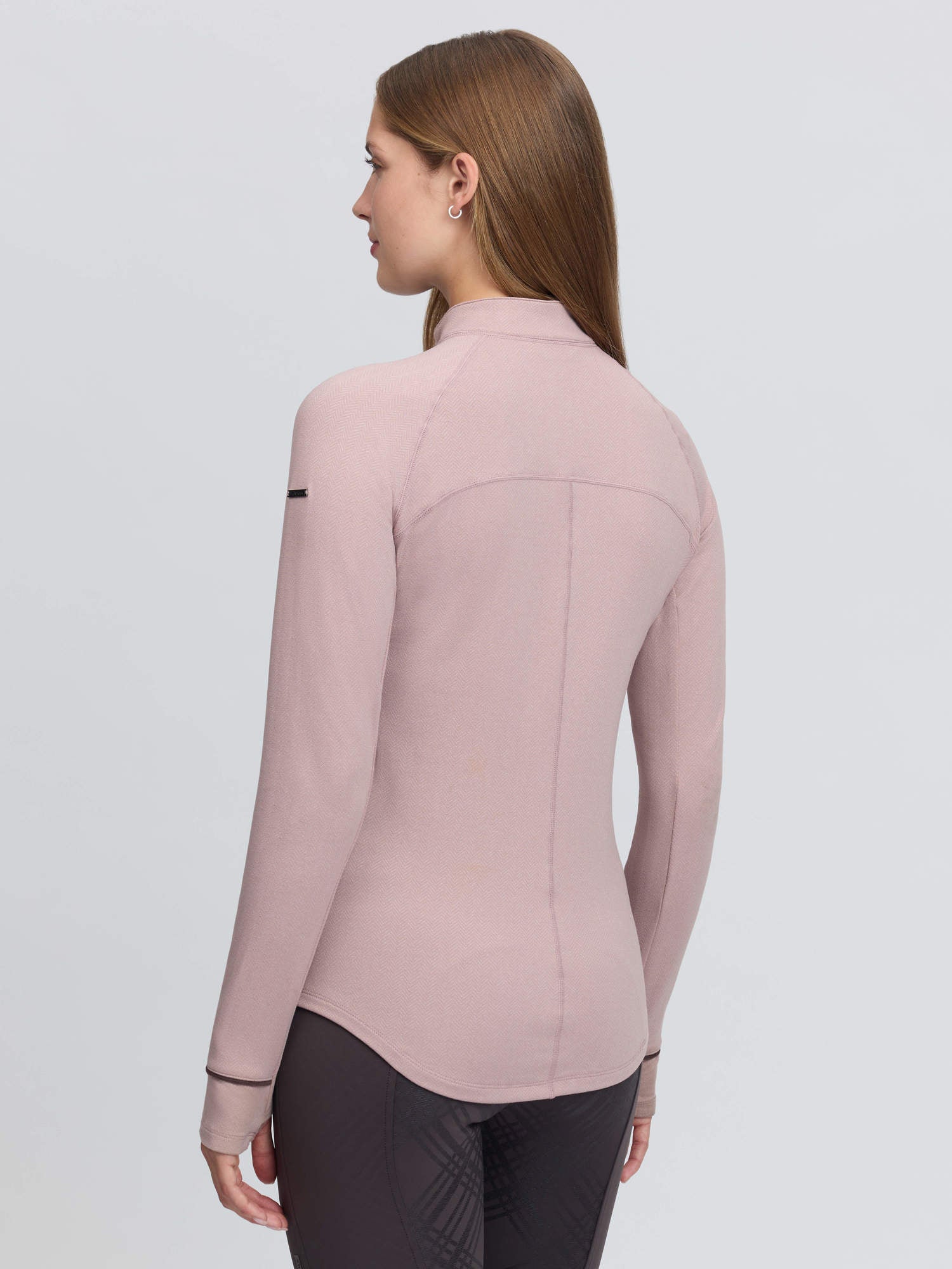 Back view of a female model wearing the Wild Rose LeMieux Heritage Herringbone Base Layer on a plain background