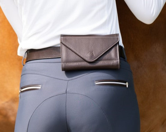 Back view of a model wearing the brown KL Select Phone Pocket over slate blue breeches