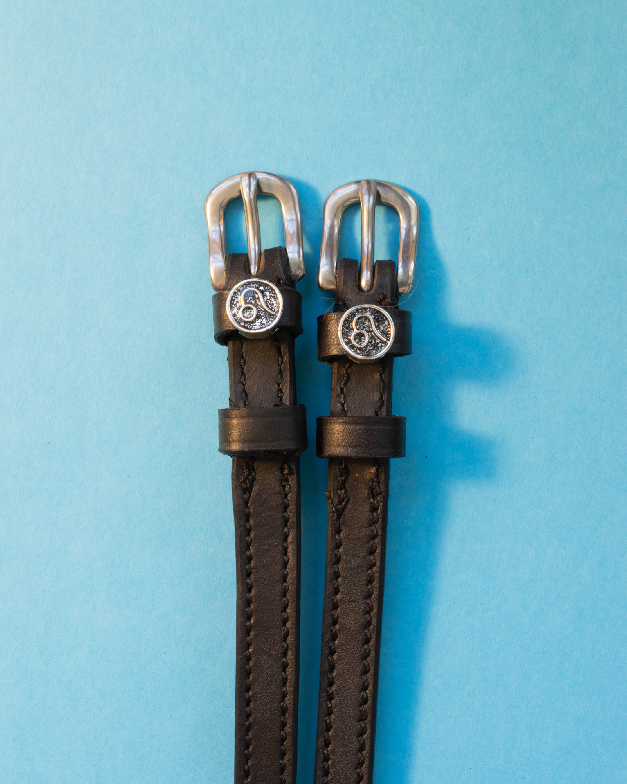View of the Leo Mane Jane Spur Straps on a blue background
