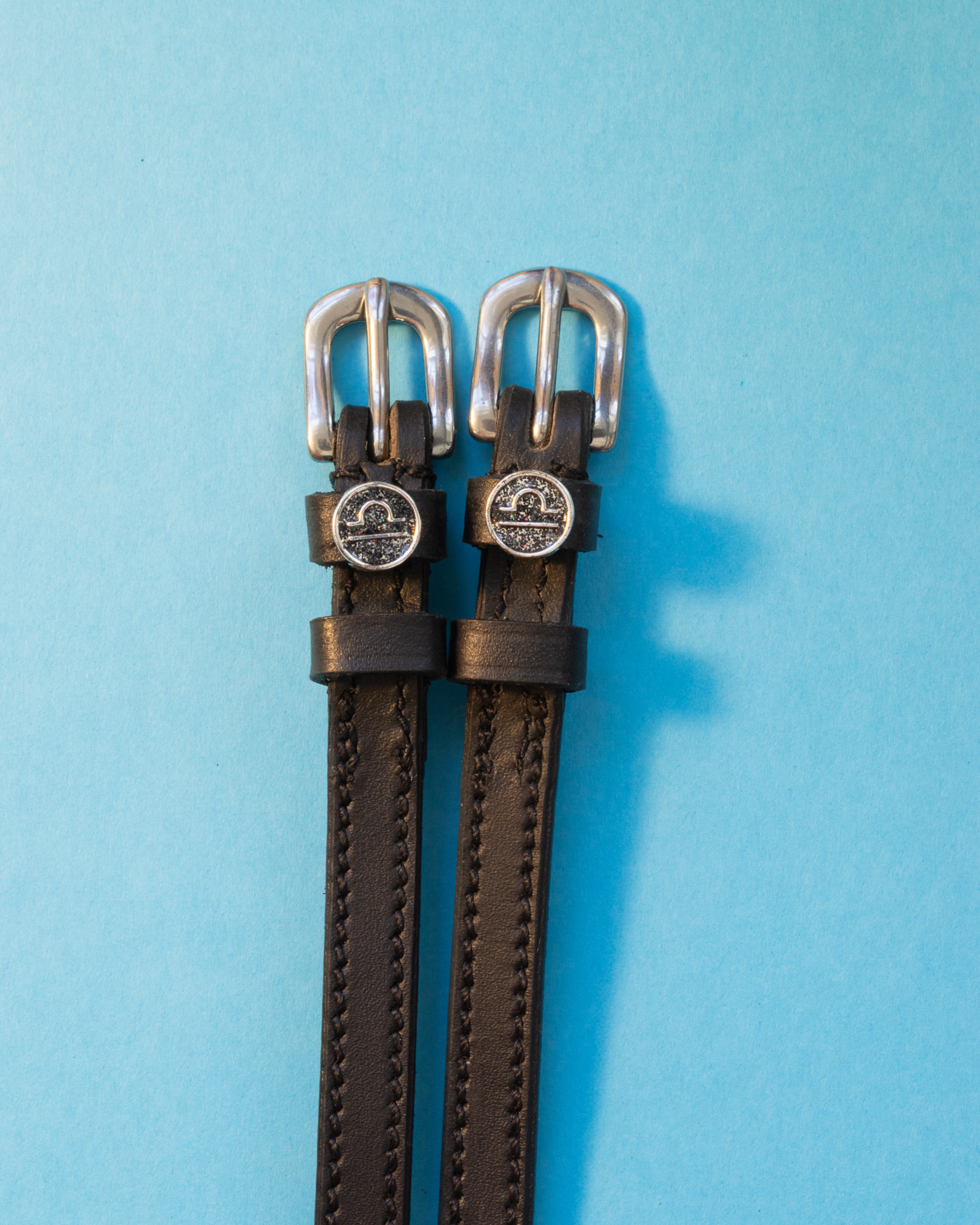 View of the Libra Mane Jane Spur Straps on a blue background