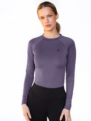 Front view of a female model wearing the Dark Violet Equestrian Stockholm Dynamic Long Sleeve Base Layer on a white background