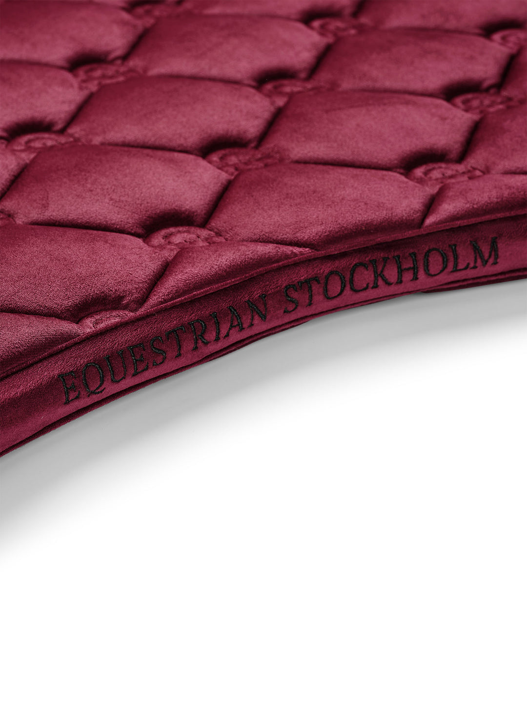 Close-up view of the spine on the Merlot Equestrian Stockholm Velvet Jump Saddle Pad on a plain background
