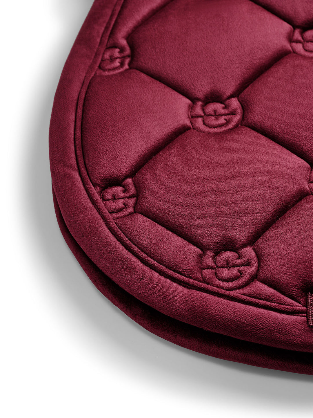 Close-up view of the edge on the Merlot Equestrian Stockholm Velvet Jump Saddle Pad on a plain background