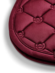 Close-up view of the edge on the Merlot Equestrian Stockholm Velvet Jump Saddle Pad on a plain background