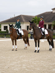 Front view of 2 models sitting on horses in an outdoor arena - one model is wearing the Sycamore Green Equestrian Stockholm Classic Show Jacket and the other is wearing the Merlot Equestrian Stockholm Classic Show Jacket