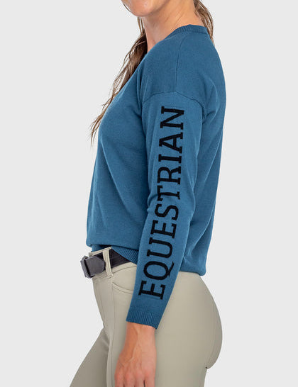 Side view of a female model wearing the Sailor Blue Kastel Crewneck Sweater on a plain background