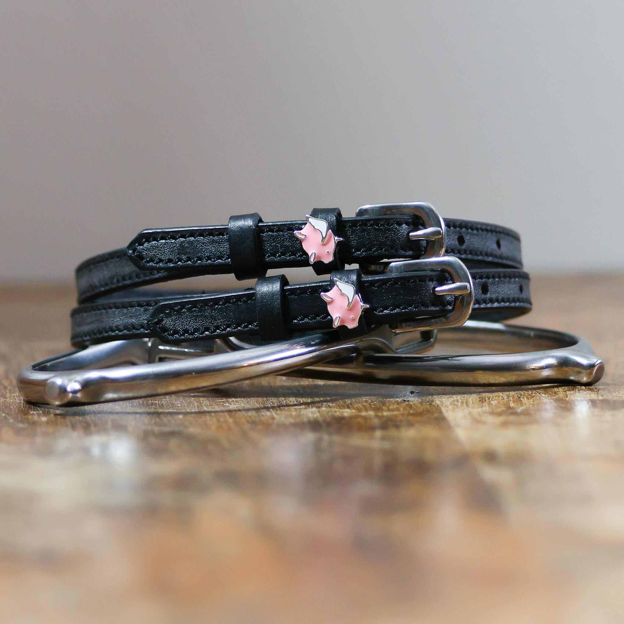 View of the Pigs Fly Mane Jane Spur Straps  on a wood table