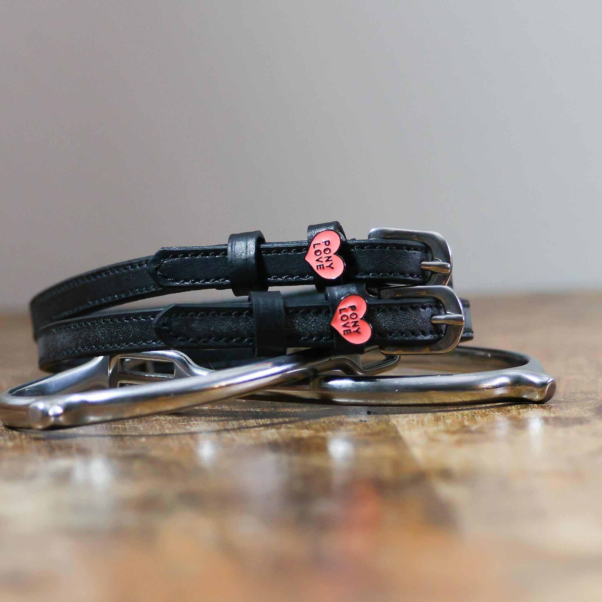 View of the Pony Love Mane Jane Spur Straps  on a wood table