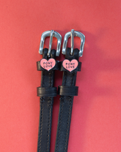 View of the Pony Love Mane Jane Spur Straps  on a plain red background