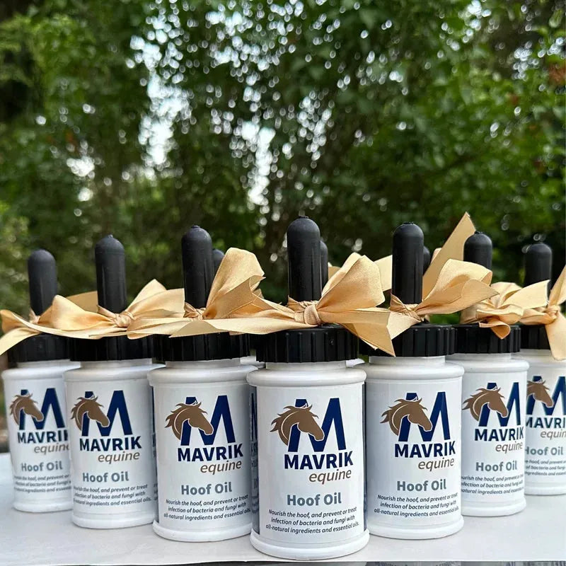 Front view of a bunch of 8 oz bottles of Mavrik Hoof Oil with trees in the background