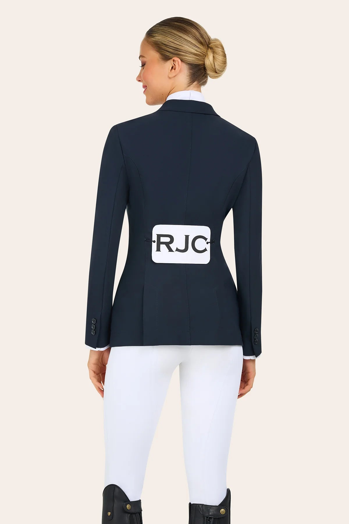 Back view of a model wearing the navy RJ Classics Victory Show Coat with RJC on the compatition number tabard on a plain background