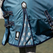 Angled side closeup view of a horse wearing the Equinavia Thunder 360 200g Detachable Neck Turnout Blanket outdoors showing the details on the front