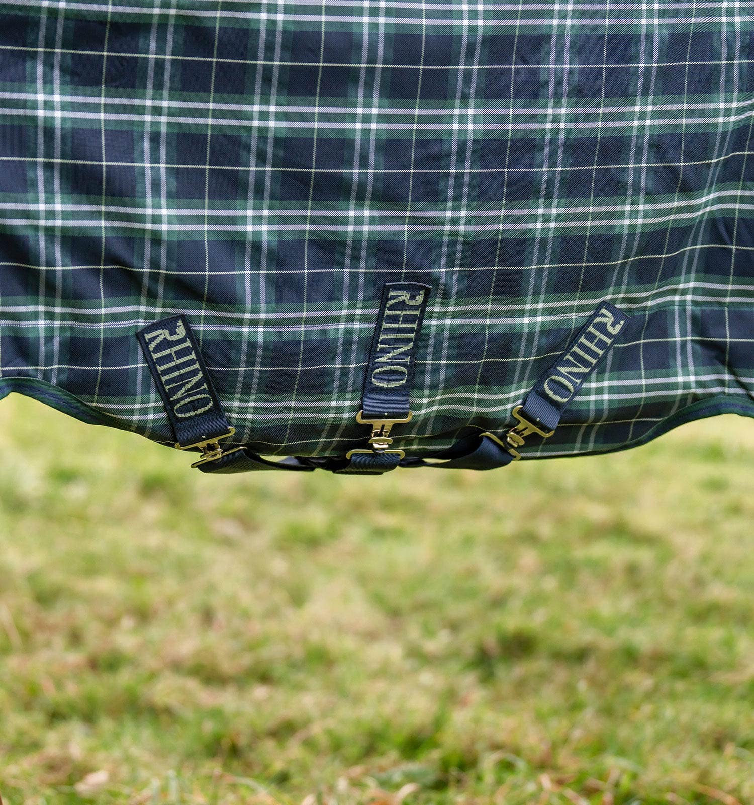 Close-up view of the 3 crossed surcingles on the Hunter Check/Green & Navy Horseware Rhino Plus Turnout 0g