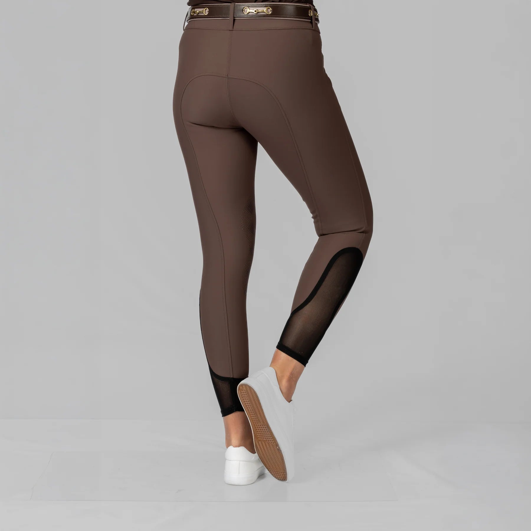 Back view of a model wearing the Dark Brown Equinavia Maud Tech Knee Patch Breeches on a plain background