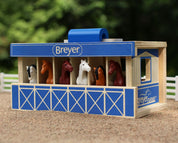 Angled front view of the Breyer Breyer Farms Wood Carry Stable staged outdoors