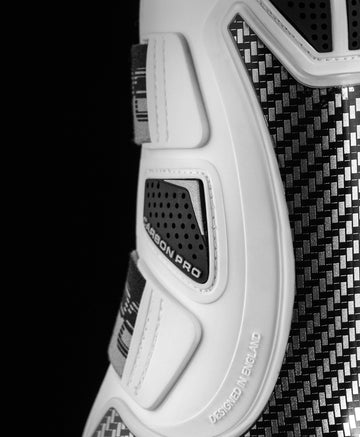 Close-up view of a white Premier Equine Carbon Pro Tendon Boot on a black background