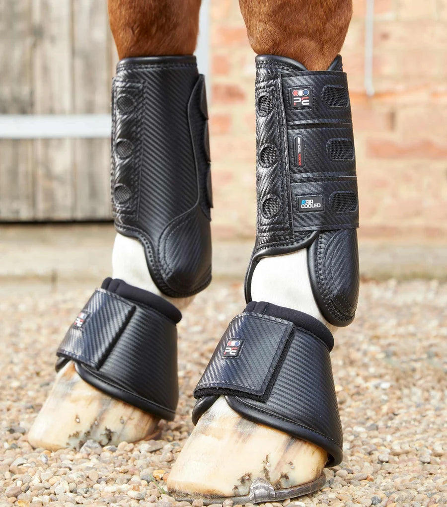 View of a horse wearing the black Premier Equine Carbon Tech Air Cooled Eventing Front Boots while standing on a pea gravel path
