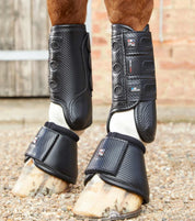 View of a horse wearing the black Premier Equine Carbon Tech Air Cooled Eventing Front Boots while standing on a pea gravel path