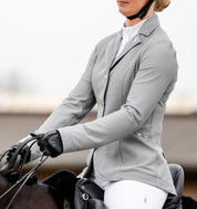 Angled side view of rider wearing the AA Platinum MotionLite Jacket in Silver Slate while riding a horse