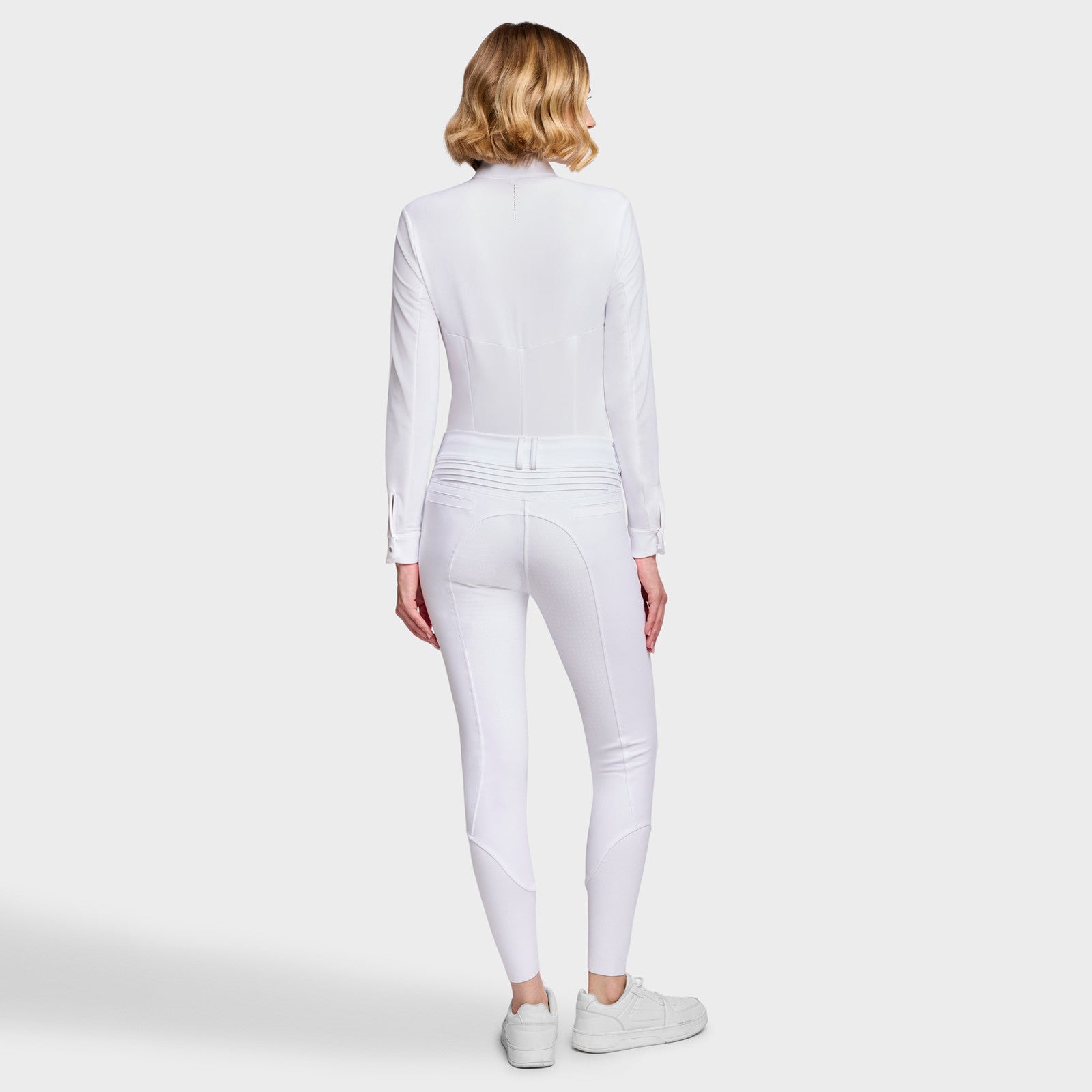 Full body back view of a female model wearing the White Samshield Chloe 3D Full Grip Breeches with a white shirt on a plain background