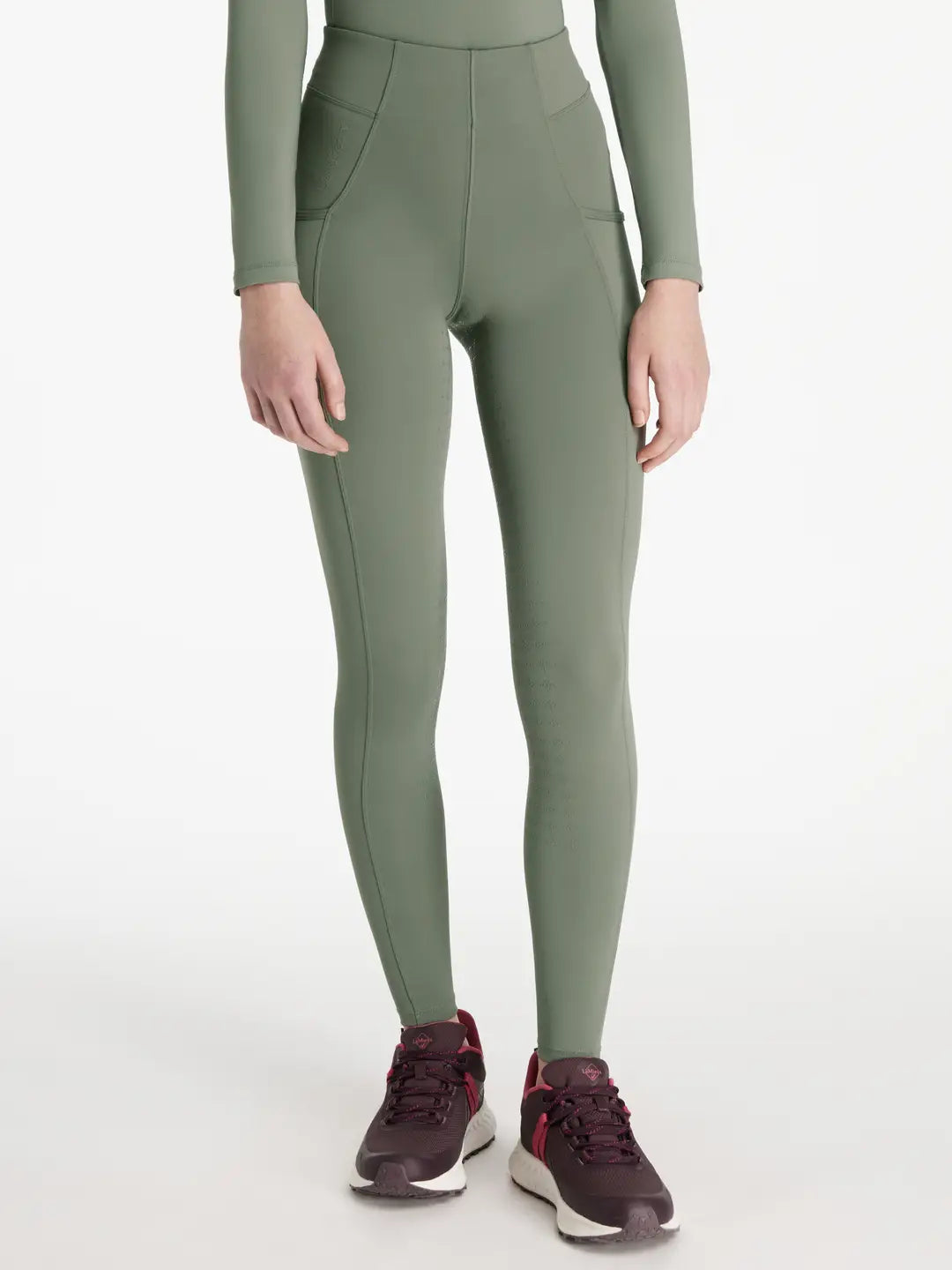 Front view of a model wearing the green Lemieux Young Rider Orla Pull On Tight on a white background