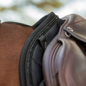Close-up side view of the withers on the Black Equinavia Bergen Crystal All Purpose Pad under a brown saddle