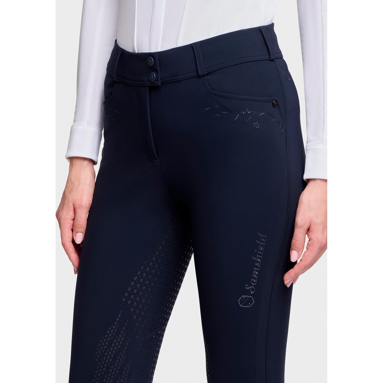 Close-up front view of a female model wearing the Navy Samshield Delice Floral Full Grip Breeches on a plain background