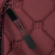 Close-up view of the D Ring keeper on the burgundy Equinavia Bergen Crystal Dressage Saddle Pad