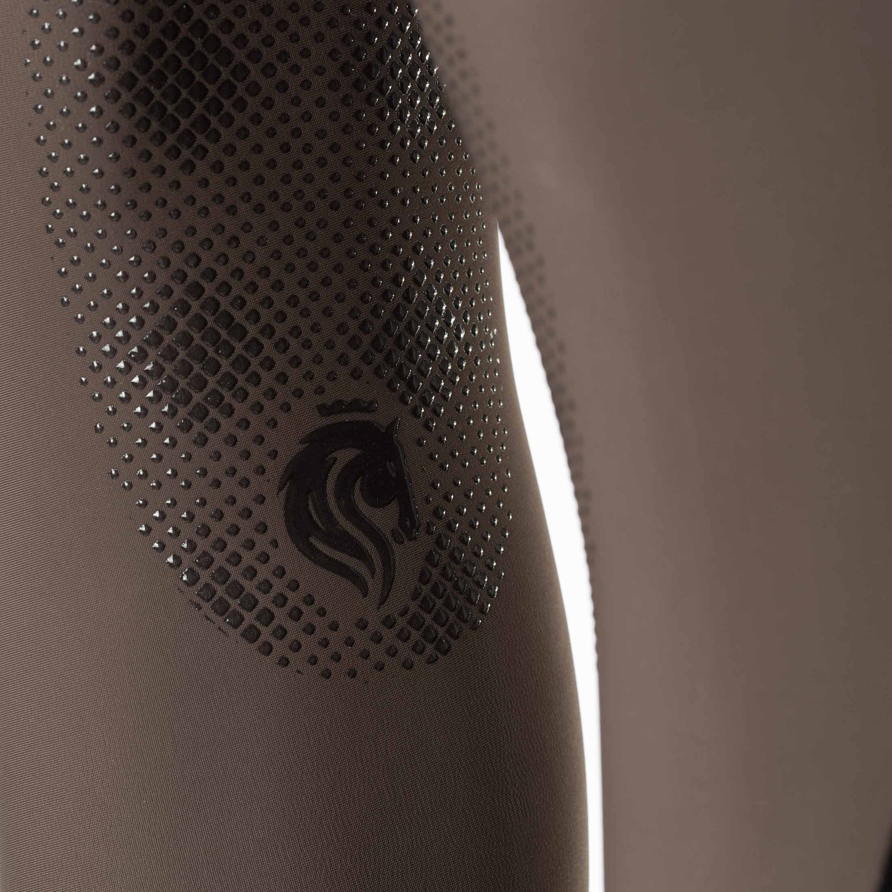Closeup view of the Dark Brown Equinavia Maud Tech Knee Patch Breeches showing the silicone grip Equinavia logo