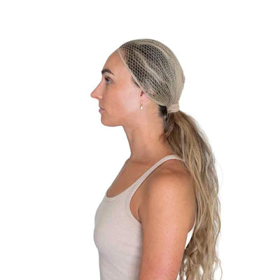 Side view of a female model wearing the Warm Blonde Ellsworth Ponytail Hairnet on a plain background