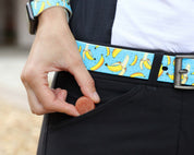 View of a model putting a Equine Elixirs Electrobites Gummie in her breeches pocket while she is wearing a banana design belt