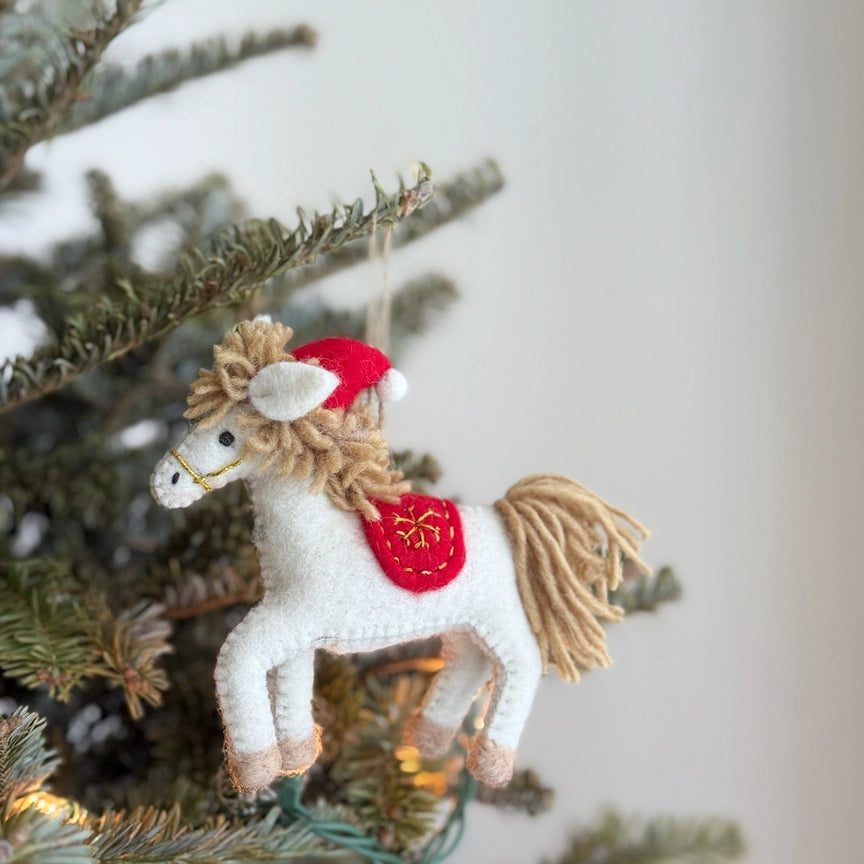 Opposite side view of the Ganapati Christmas Horse Felt Ornament hung on a tree