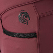 Side closeup view of the Burgundy Equinavia Kristina Full Seat Breeches on a plain background showing the pocket detail and Equinavia logo