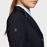 Close-up view of the logo on the shoulder of the Black Samshield Alcantara Long Frac as worn by a female model on a plain background
