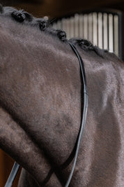 Close-up view of a dark colored horse wearing the Black LeMieux Rubber Reins over it's neck