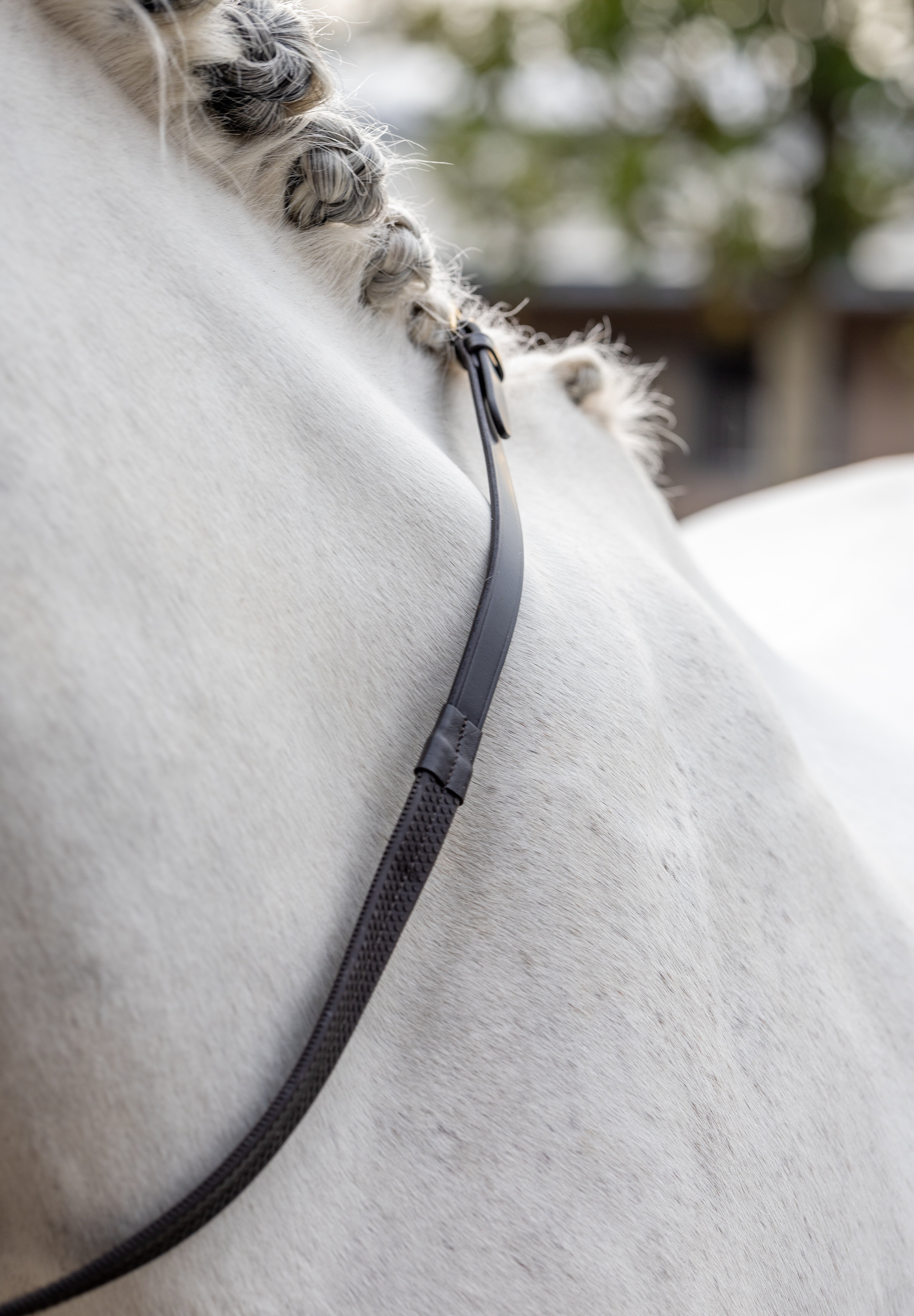 View of the Brown/Brass LeMieux Rubber Reins against a gray horse's neck
