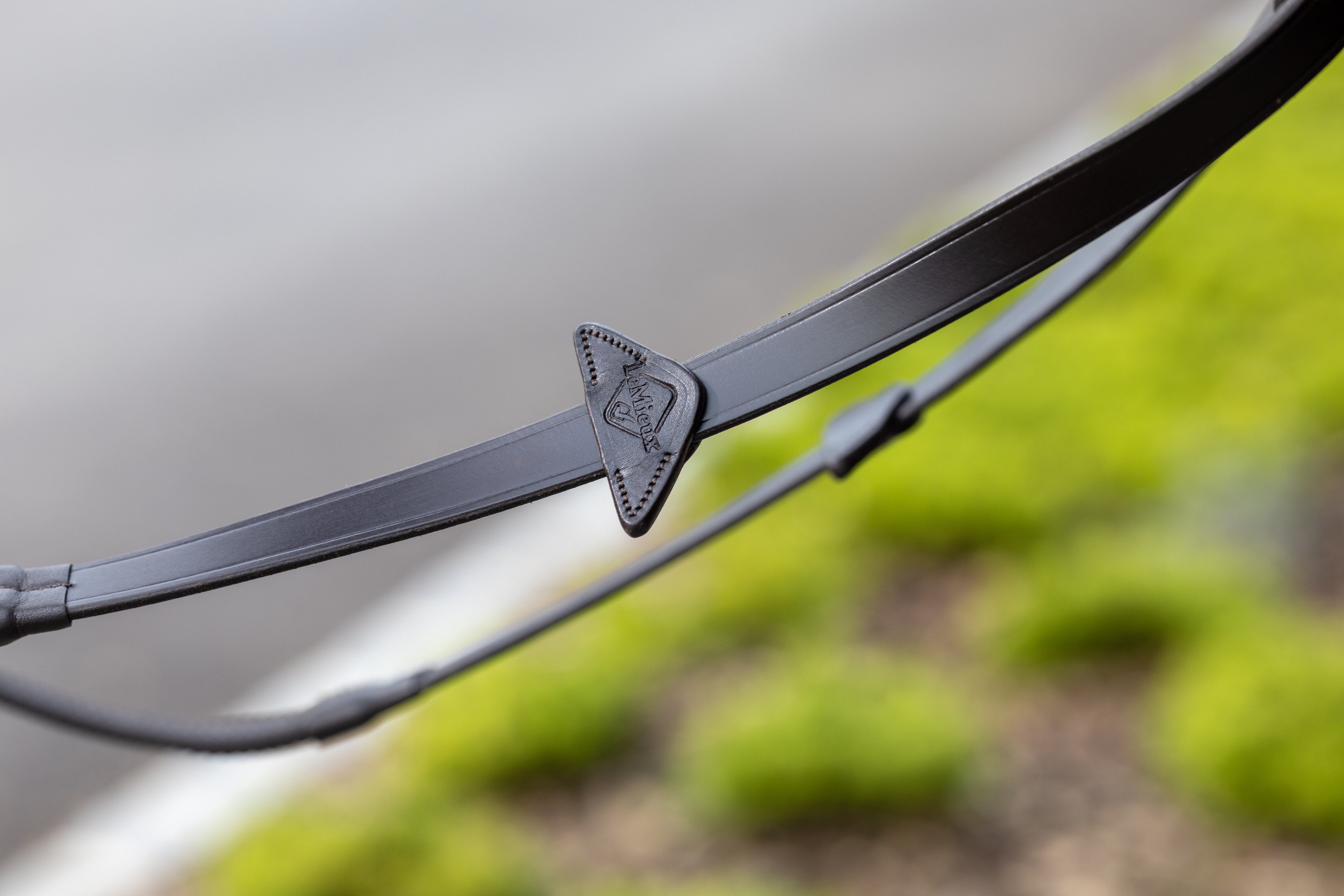 Close-up view of the LeMieux name on the stopper of the Brown/Brass LeMieux Rubber Reins