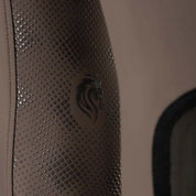 Closeup view of the Dark Brown Equinavia Maud Tech Full Seat Breeches showing the silicone grip Equinavia logo