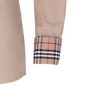 Tan button up blouse with white trim and inner plaid print shown zoomed in on cuff on plain white background