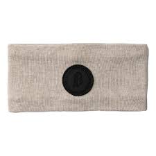 A light beige ribbed knit headband with a contrasting black circular patch in the center, shown against a plain white background.