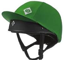 A green equestrian riding helmet with a black chin strap and visor, featuring a small white diamond-shaped logo on the visor and a larger logo patch on the crown.