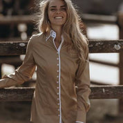 Tan button up blouse with white trim and inner plaid print shown on model on natural background