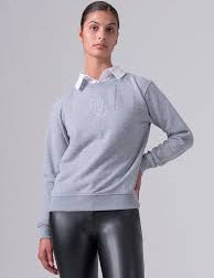 Light grey crewneck sweatshirt with stitched center monogram shown on model on light grey background