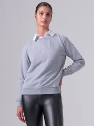 Light grey crewneck sweatshirt with stitched center monogram shown on model on light grey background