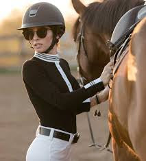 Black long sleeved top with white collar and bib shown on model with horse