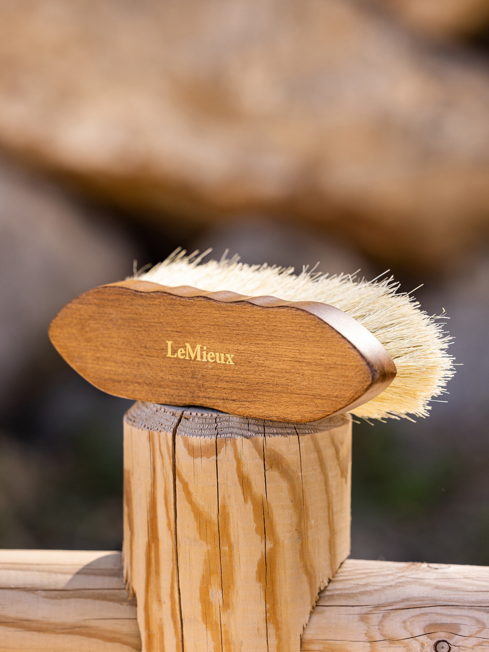 View of the LeMieux Artisan Deep Clean Dandy Brush on a wooden fence post