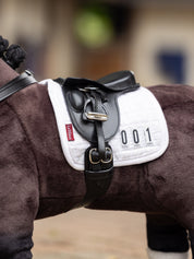 Close-up side view of a bay toy pony wearing the LeMieux Toy Pony Dressage Saddle and Girth