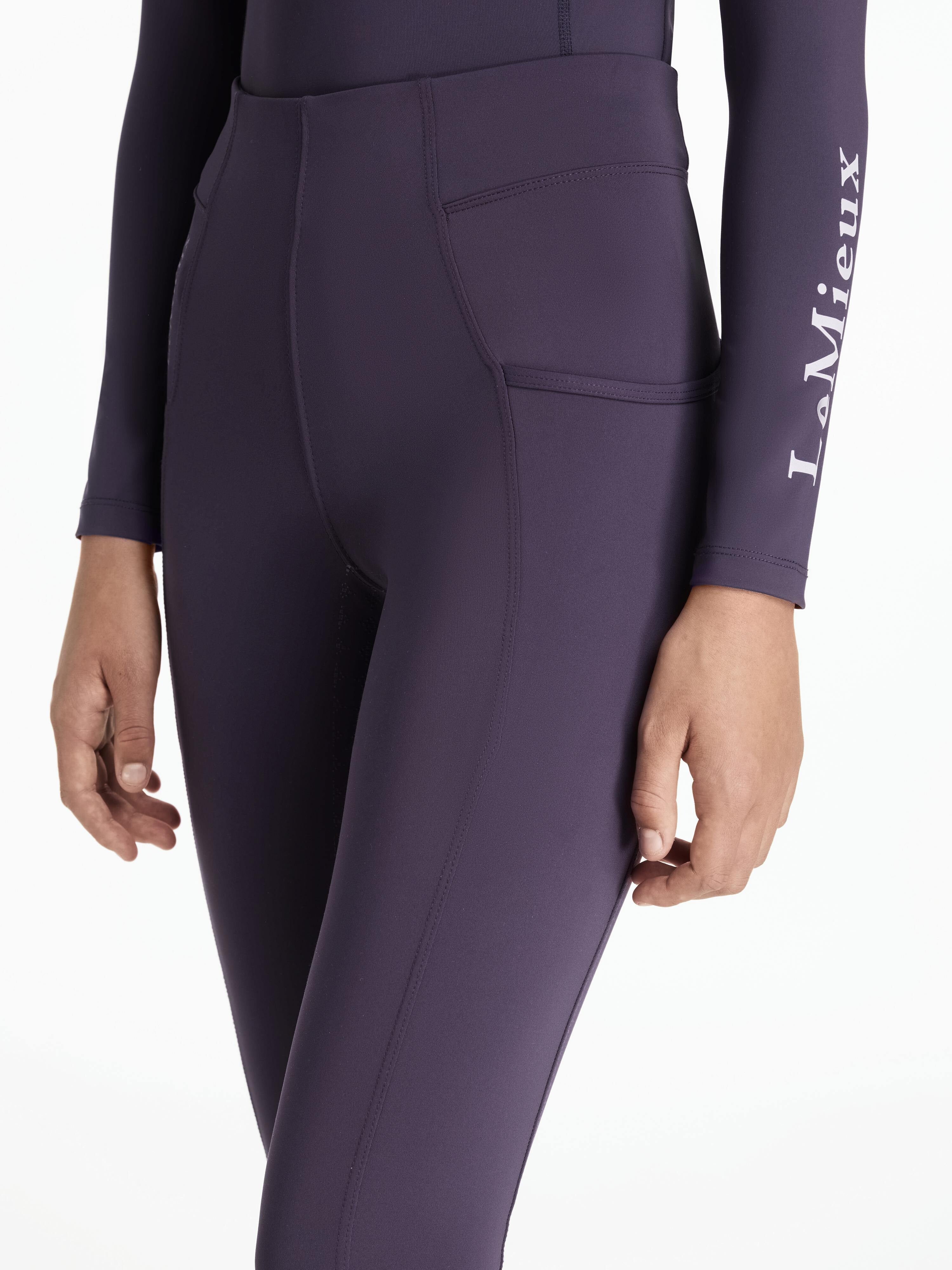 Angled front view of a model wearing the purple Lemieux Young Rider Orla Pull On Tight on a white background