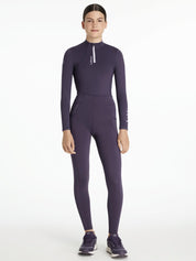 Full body front view of a young female model wearing the purple Lemieux Young Rider Orla Pull On Tight with coordinating purple top on a white background