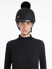 Front view of a female model wearing the Black Houndstooth LeMieux Aspen Hat Silk over a helmet on a plain background